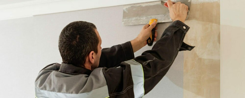 man-is-cutting-wallpaper-maintenance-repair-works-renovation-flat-apartment-renovation-restoration-idea-indoors